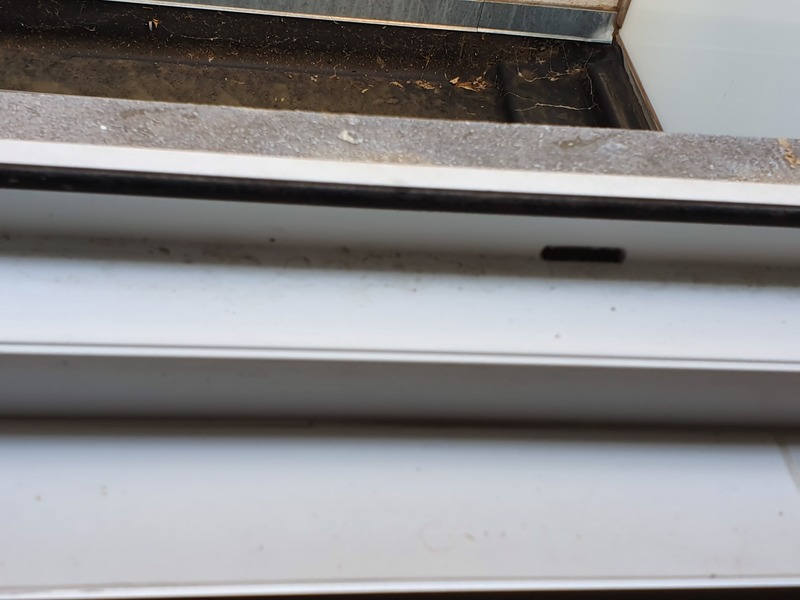 Close-up van een wit raamkozijn dat MT Cleaning grondig reinigt