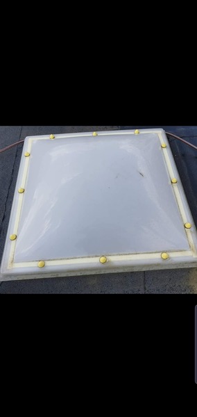 Voor en na reiniging van een vierkante lichtkoepel op een plat dak (voor de reiniging)