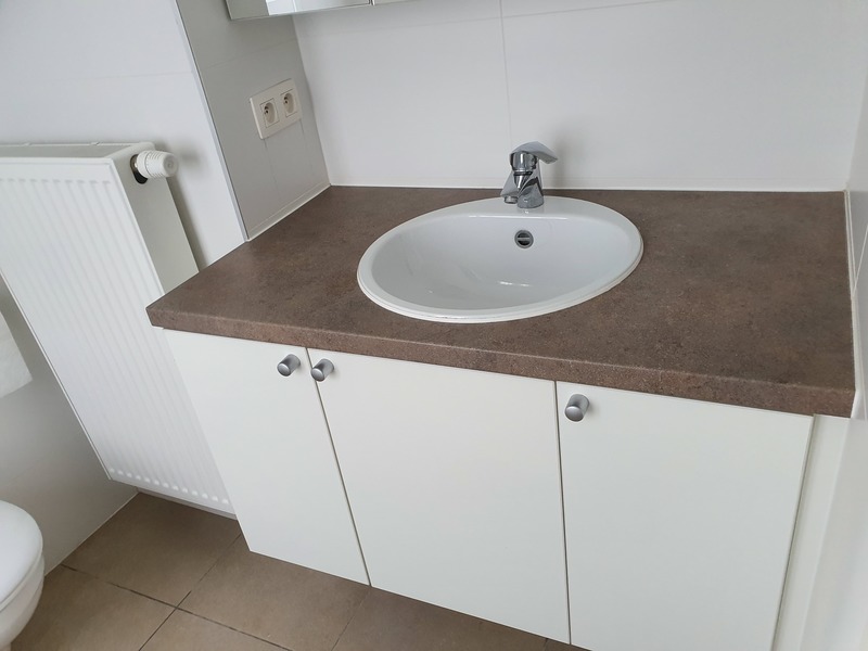 Dezelfde wastafel glanzend schoon na de opleveringsschoonmaak